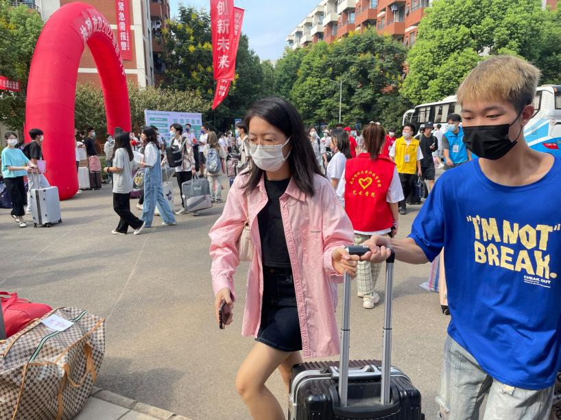 图4:李文潞老师帮助学生搬运行李.png 图4:李文潞老师帮助学生搬运行李.png