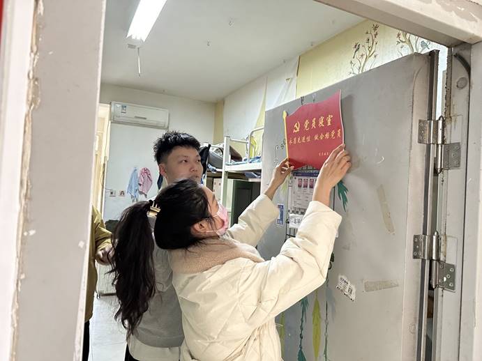 学生第二党支部书记为党员寝室挂牌.jpg 学生第二党支部书记为党员寝室挂牌.jpg