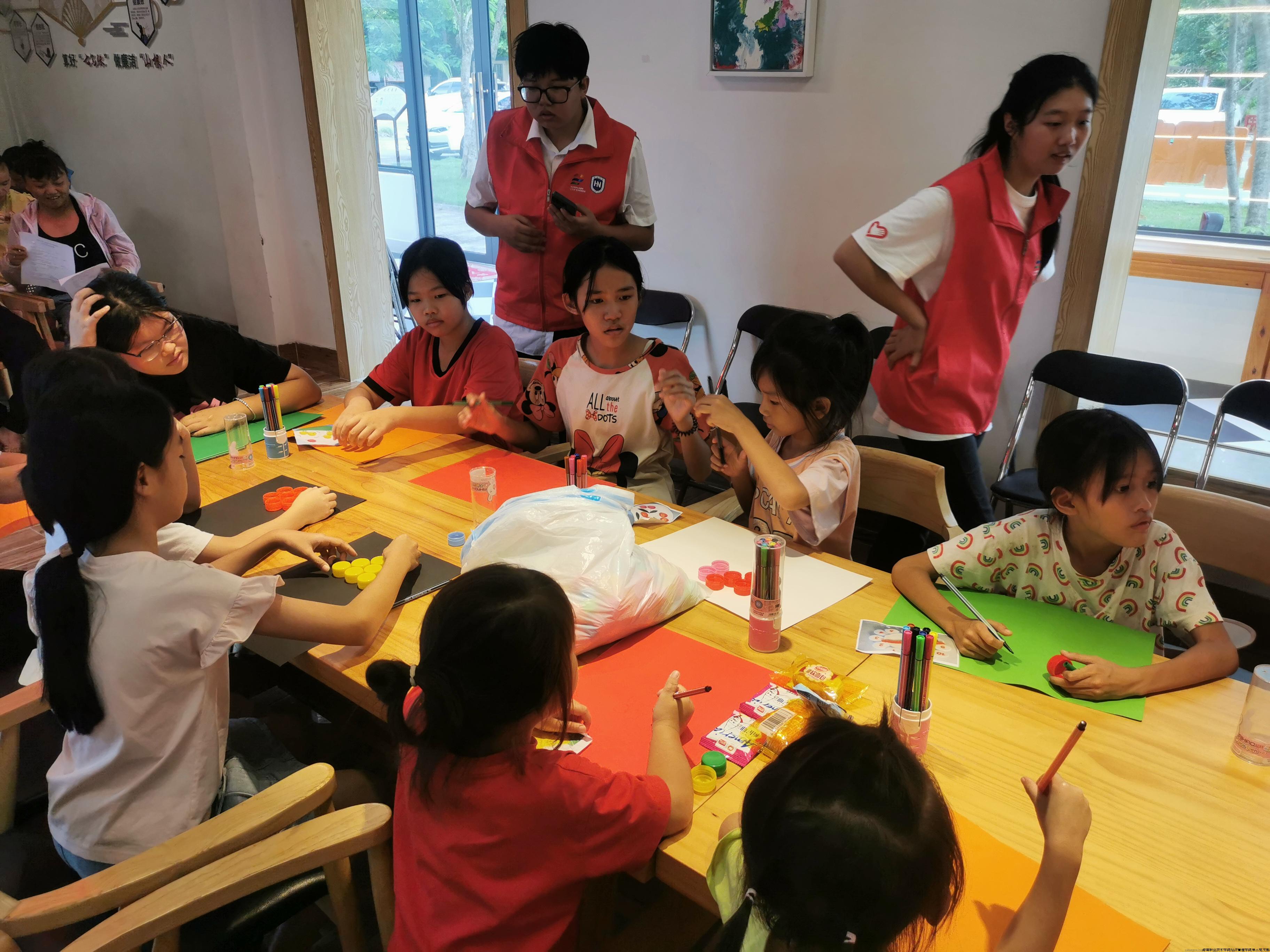志愿者指导万宁排溪村小朋友用清洗消毒过的废弃瓶盖作画,进行废物再利用.jpg 志愿者指导万宁排溪村小朋友用清洗消毒过的废弃瓶盖作画,进行废物再利用.jpg