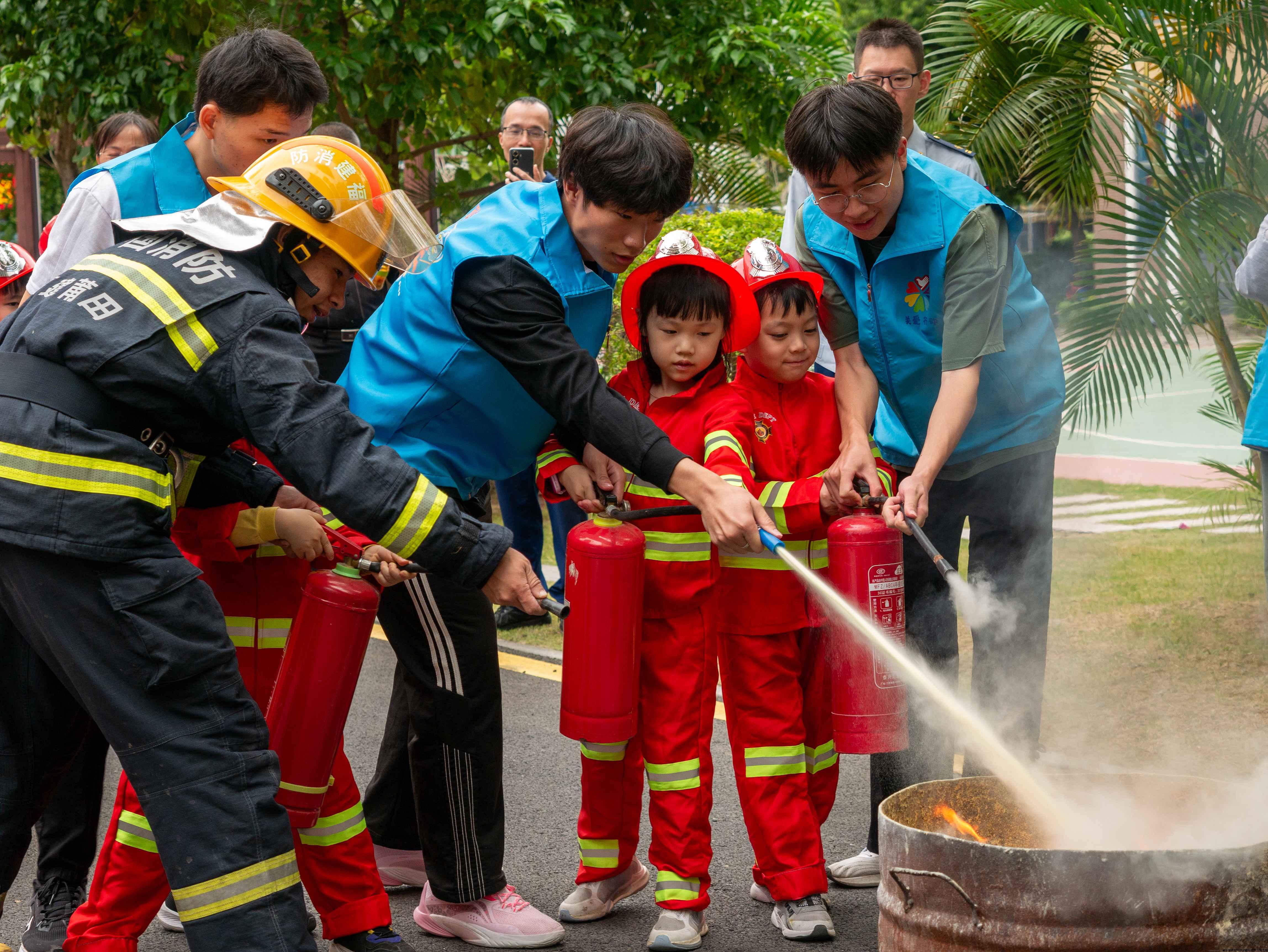图为消防员和服务队队员教萌娃使用灭火器(1).jpg 图为消防员和服务队队员教萌娃使用灭火器(1).jpg