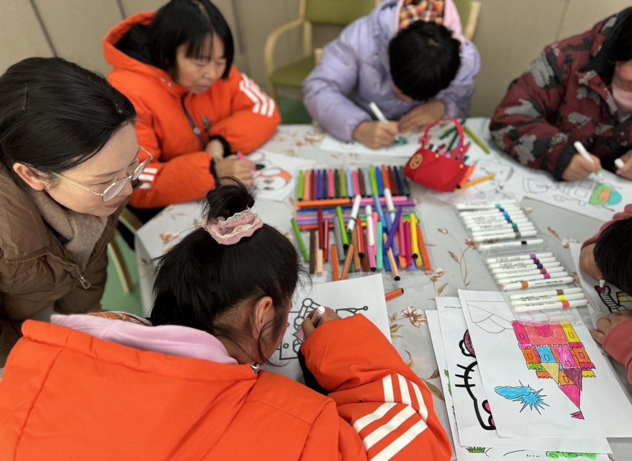 支部党员指导孩子们为机器人图画涂色