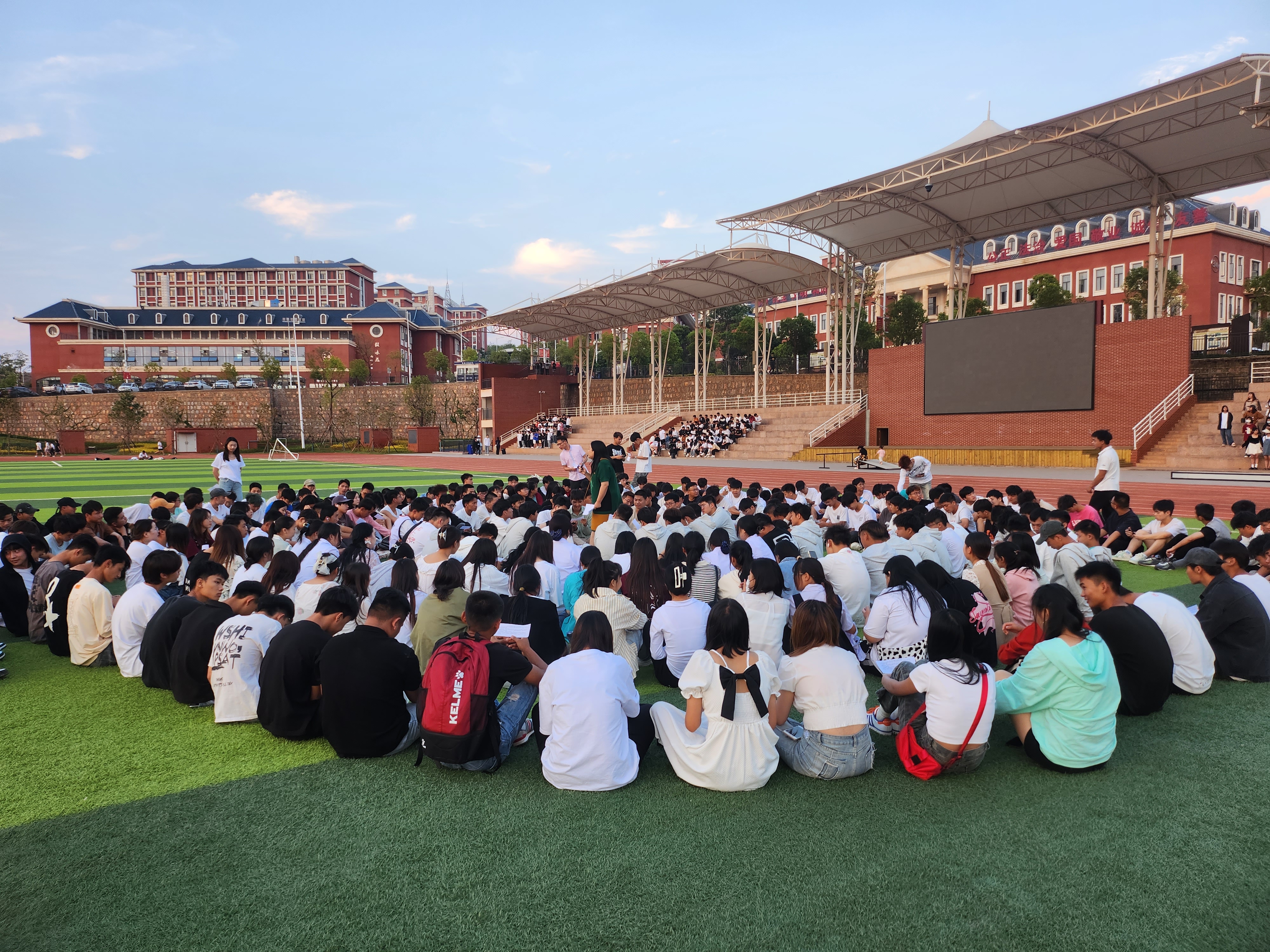 图9行走的思政课——师生在足球场上学习习近平总书记致云南大学建校100周年贺信精神