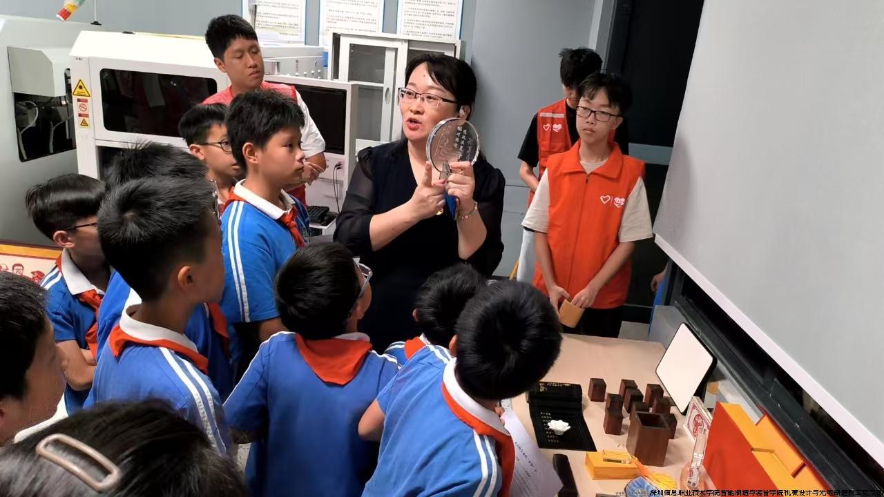 同学们参观智能光电制造技术专业激光加工实训室，认真观察激光内雕特色作品，并向老师详细了解加工原理