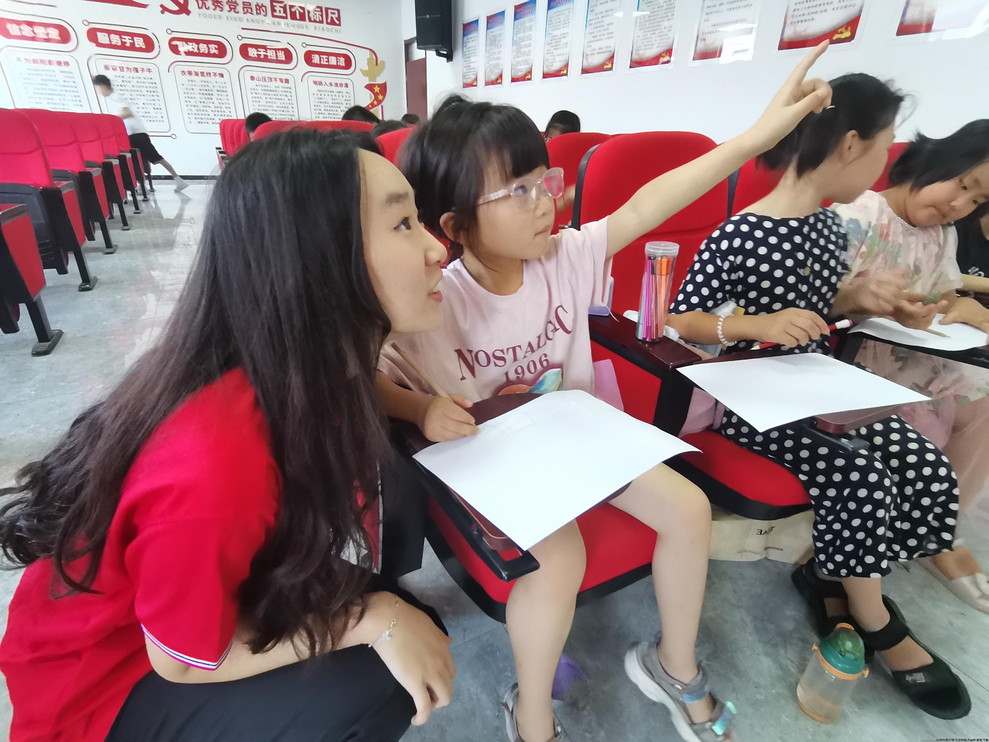 图为志愿者协助孩子们绘画 王佳妮摄